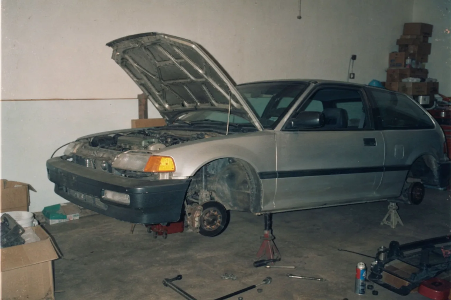 Eerste project-auto op assen in de garage, dozen op de achtergrond